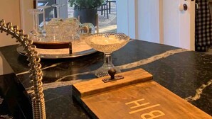 A kitchen with a wooden countertop, a glass bowl, and a metal rack. - Historic Boyd Harvey House and Grounds 2 Bedroom Home by RedAwning (Knoxville)