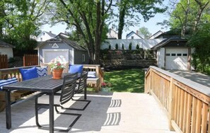 An outdoor patio area with a wooden deck, a table with chairs, and a small seating area with cushions. - Oakley Square 3br Charmer - Total Walkability 3 Bedroom Home by RedAwning (Cincinnati)