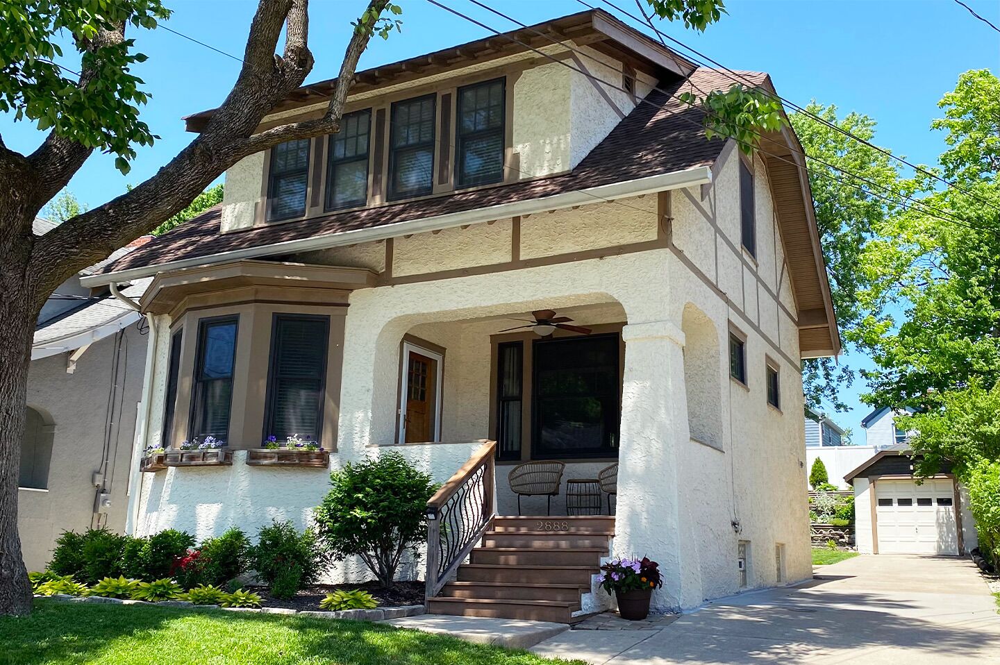 A two-story house with a front porch, a covered entryway, and a garage.