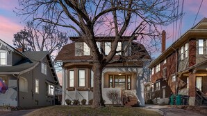 A two-story house with a large tree in front, a garage, and a driveway. - Oakley Square 3br Charmer - Total Walkability 3 Bedroom Home by RedAwning (Cincinnati)