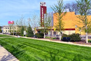 A building with a large '20th Century' sign, a well-maintained lawn, and a pedestrian crossing. - Oakley Square 3br Charmer - Total Walkability 3 Bedroom Home by RedAwning (Cincinnati)