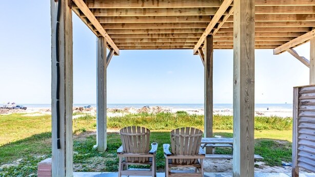 A wooden beach gazebo with two Adirondack chairs facing the ocean. - The Shore House 3 Bedroom Home by RedAwning (Port Bolivar)