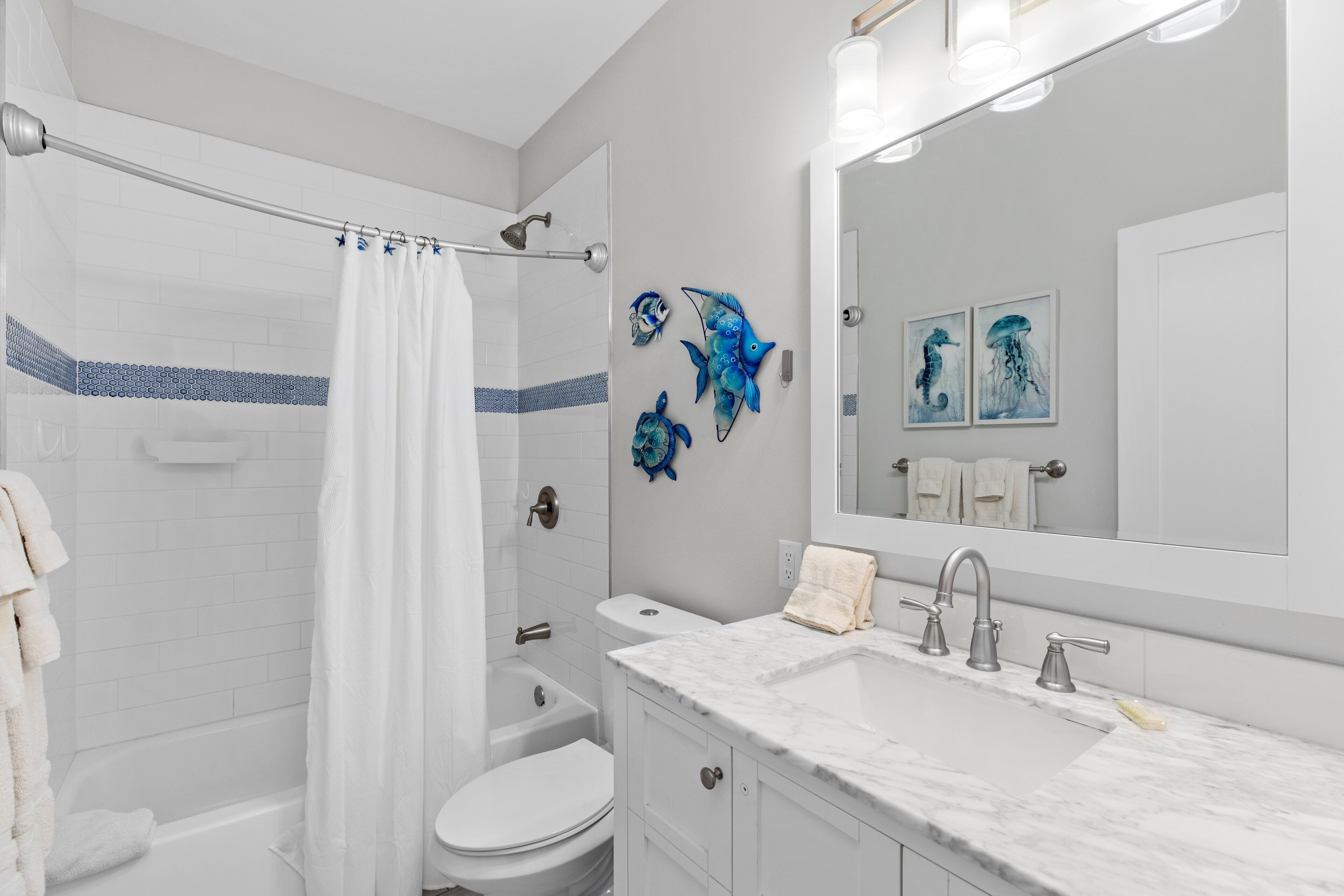 A modern bathroom with a bathtub, toilet, and sink.