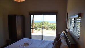 Un dormitorio con cama, armario y vistas al exterior.