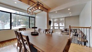 A spacious dining area with a large wooden table, several chairs, and a modern pendant light. - Summer Hikes From Out Your Front Door and Free Village Gondola! by RedAwning (Mammoth Lakes)