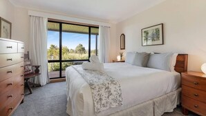 A bedroom with a large bed, a dresser, a nightstand, a window with curtains, and a framed picture on the wall. - Ithaca Cottage by Your Innkeeper Mudgee (Frog Rock)
