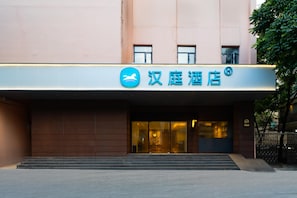 A hotel entrance with a signboard, steps leading up to the entrance, and a tree to the right. - Hanting Premium Hotel Guangzhou Memorial Hall Metr (Guangzhou)
