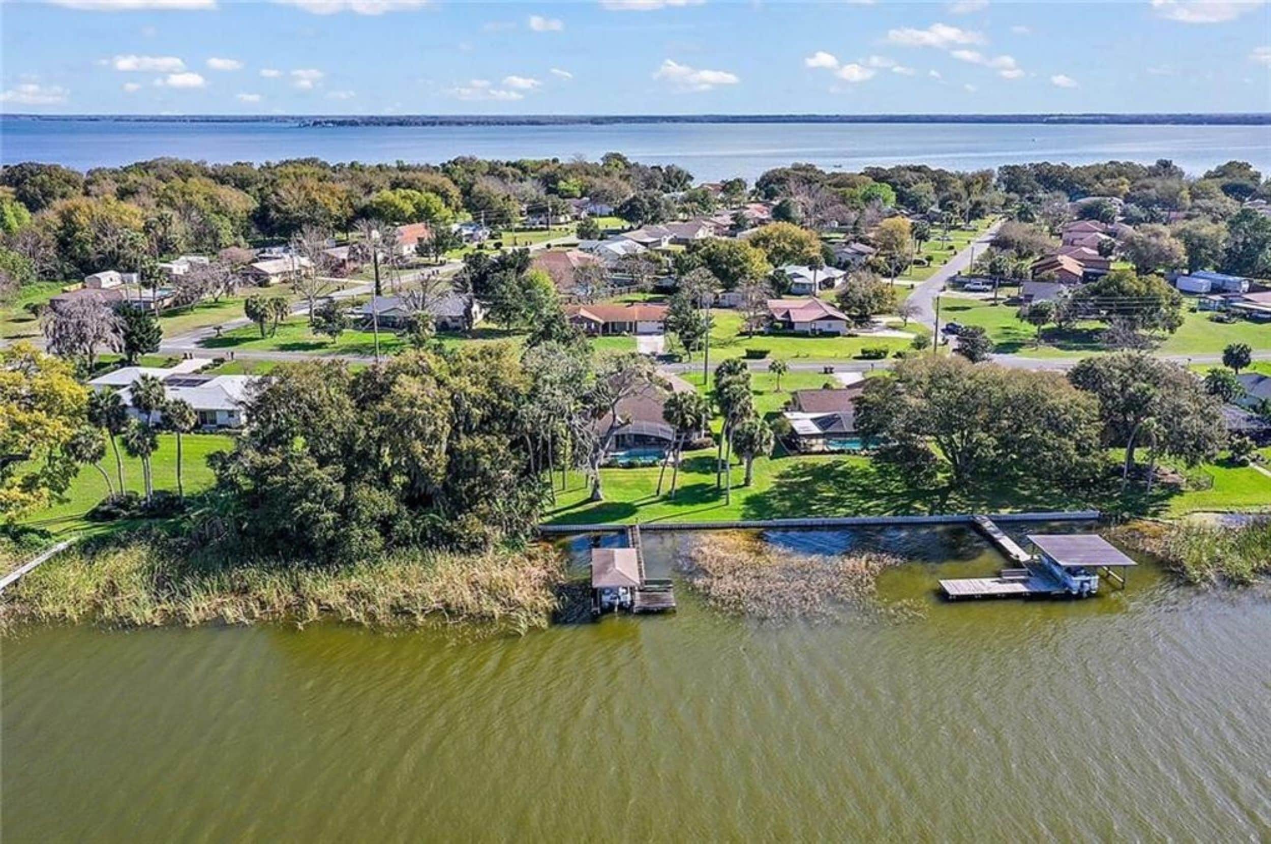 Zona residencial con casas, un muelle y una masa de agua.