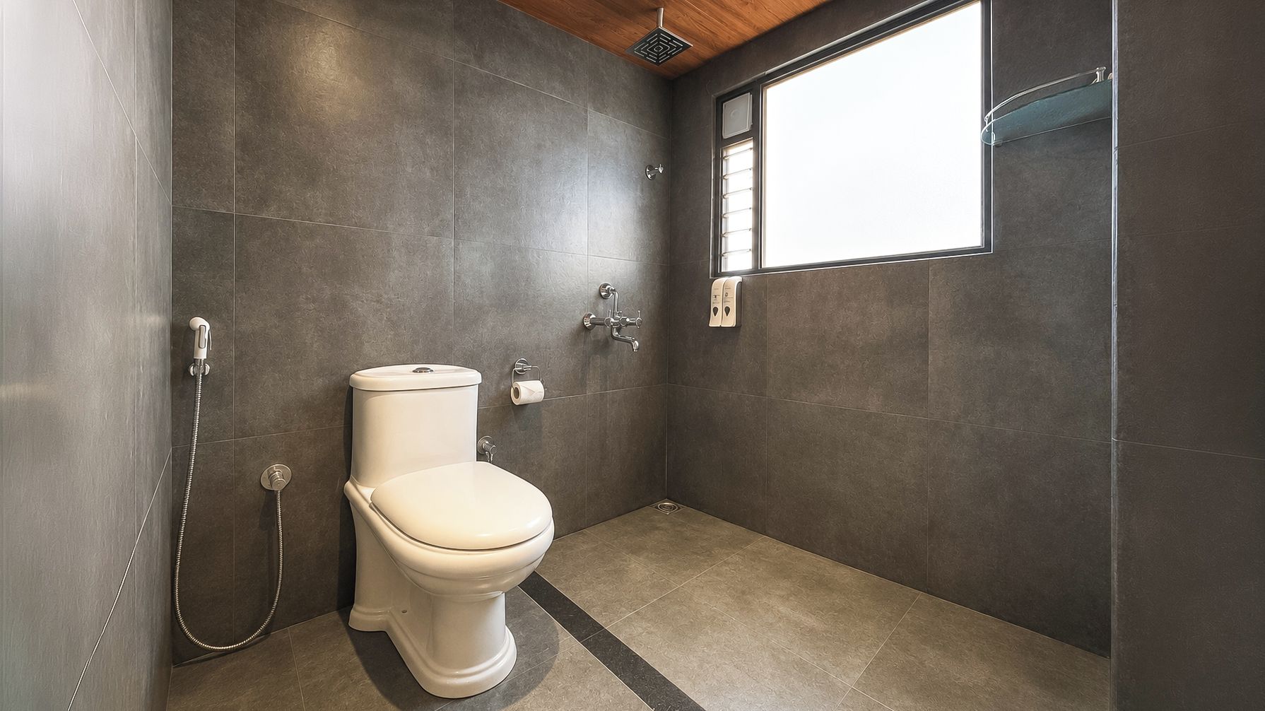 Un baño moderno con inodoro, ducha y ventana que deja entrar luz natural.