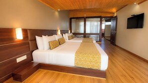 A hotel room with a large bed, wooden headboard, bedside lamps, and a flat-screen TV. - Sumitel Vista 800m from Mall Road (Darjeeling)