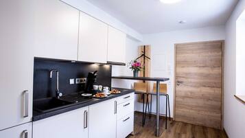 Een koelkast, een koffiezetapparaat/waterkoker, een waterkoker