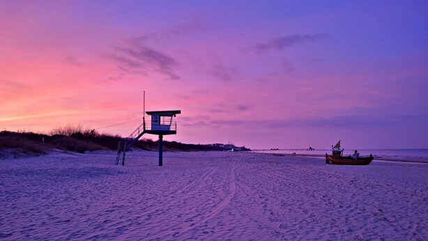 A lifeguard tower on a beach with a boat in the background. - Wohnung 01 EG - Villa Adebar (Heringsdorf)