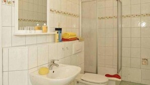 Une salle de bain avec un lavabo, des toilettes et une douche.