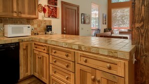 A kitchen with wooden cabinets, a microwave, and a dishwasher.