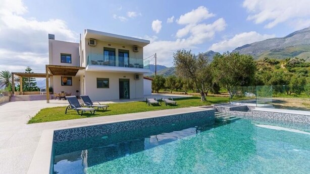 A modern two-story house with a swimming pool, outdoor seating, and a view of mountains. - Terra Divina Damnoni (Agios Vasileios)