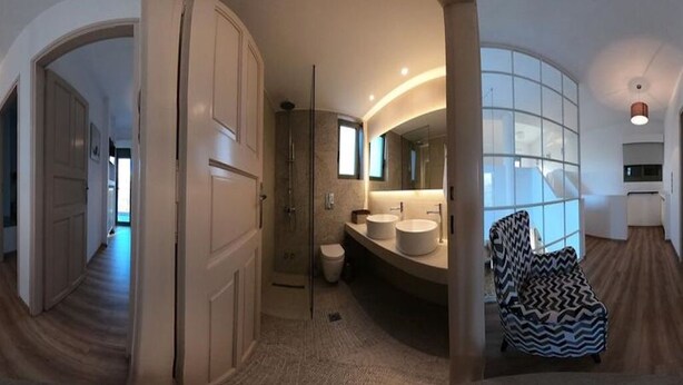 Un baño moderno con cabina de ducha a ras de suelo, tocador doble y un espejo grande.