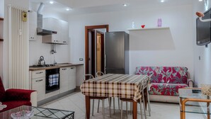 A compact living space with a kitchenette, dining area, and seating. - The House of Dreams of Serena in San Pietro (Rome)