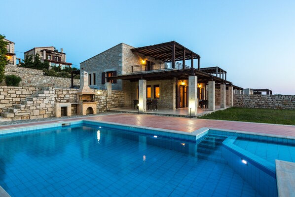A modern house with a swimming pool, stone walls, and a balcony. - Villa Poseidon Lefkogis (Agios Vasileios)