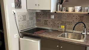 A compact kitchen with a built-in dishwasher, a stainless steel sink, and a small countertop. - Room-beautiful Bedroom for 4 People in L (Thasos)