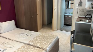 A hotel room with a bed, a wardrobe, and a kitchenette. - Room-beautiful Bedroom for 4 People in L (Thasos)