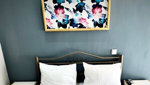 Un lit bien fait, avec du linge de lit blanc et deux serviettes pliées au pied du lit.