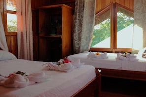A hotel room with two beds, each with neatly folded towels and a small table. - Triple Room With sea and Mountain Views Perfecto for Couples (Drake Bay)