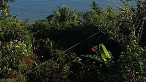 A view of a calm sea with a distant landmass and a buoy.