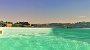 A clear view of a swimming pool with a view of a hilly landscape in the background. - Villa Sole Marche Exclusive Pool Jacuzzi Parking (Castelplanio)