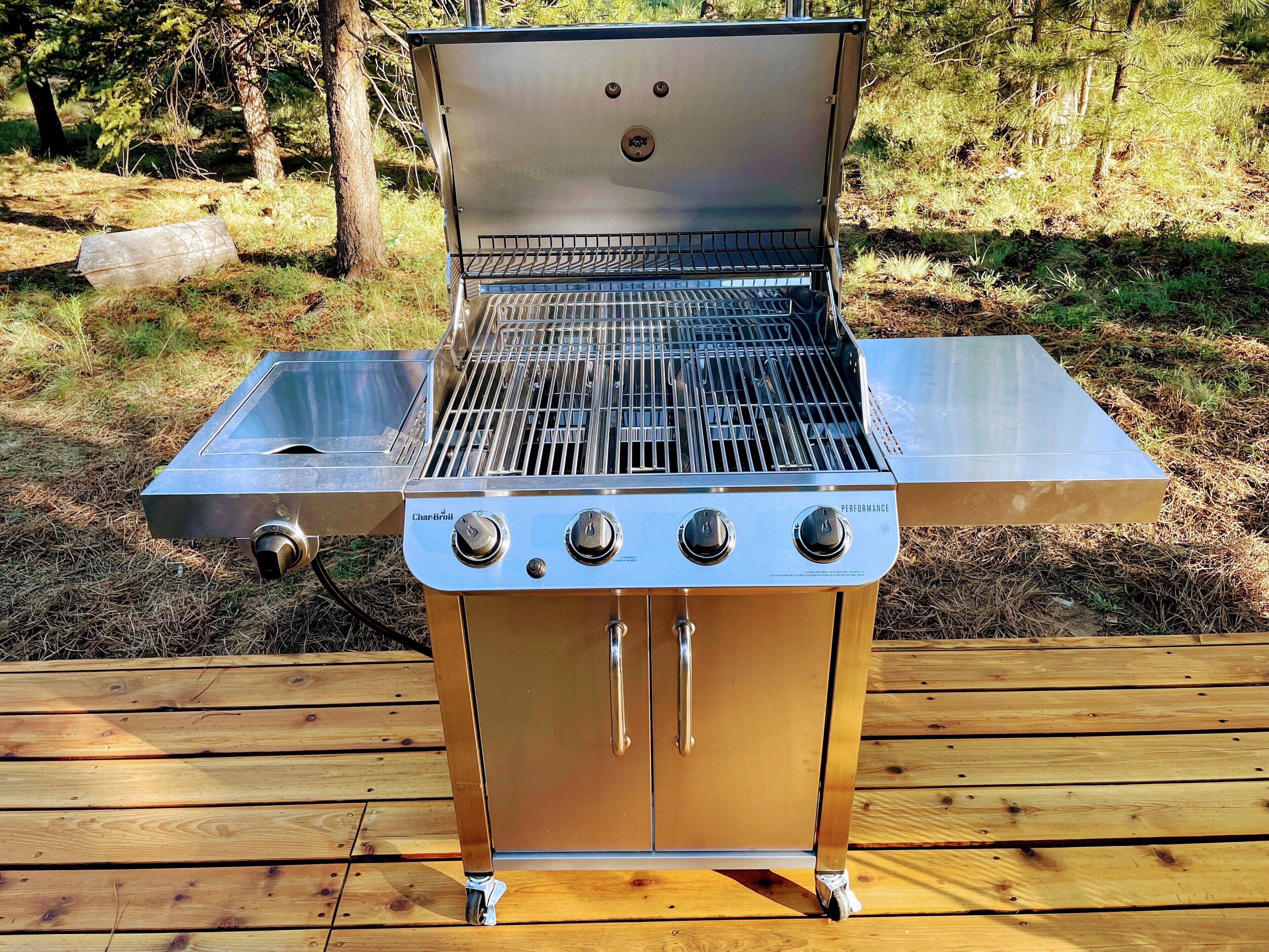 Een draagbare gasgrill met een roestvrijstalen afwerking, een bijpassende brander en een bedieningspaneel met drie knoppen.