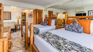 Ett hotellrum med två sängar, en sittgrupp med en soffa, ett litet bord och en spegel.