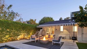 A modern outdoor patio with a fire pit, seating, and a swimming pool. - Eclectic & Stylish Home - Centrally located w/ heated pool, & more! (Phoenix)