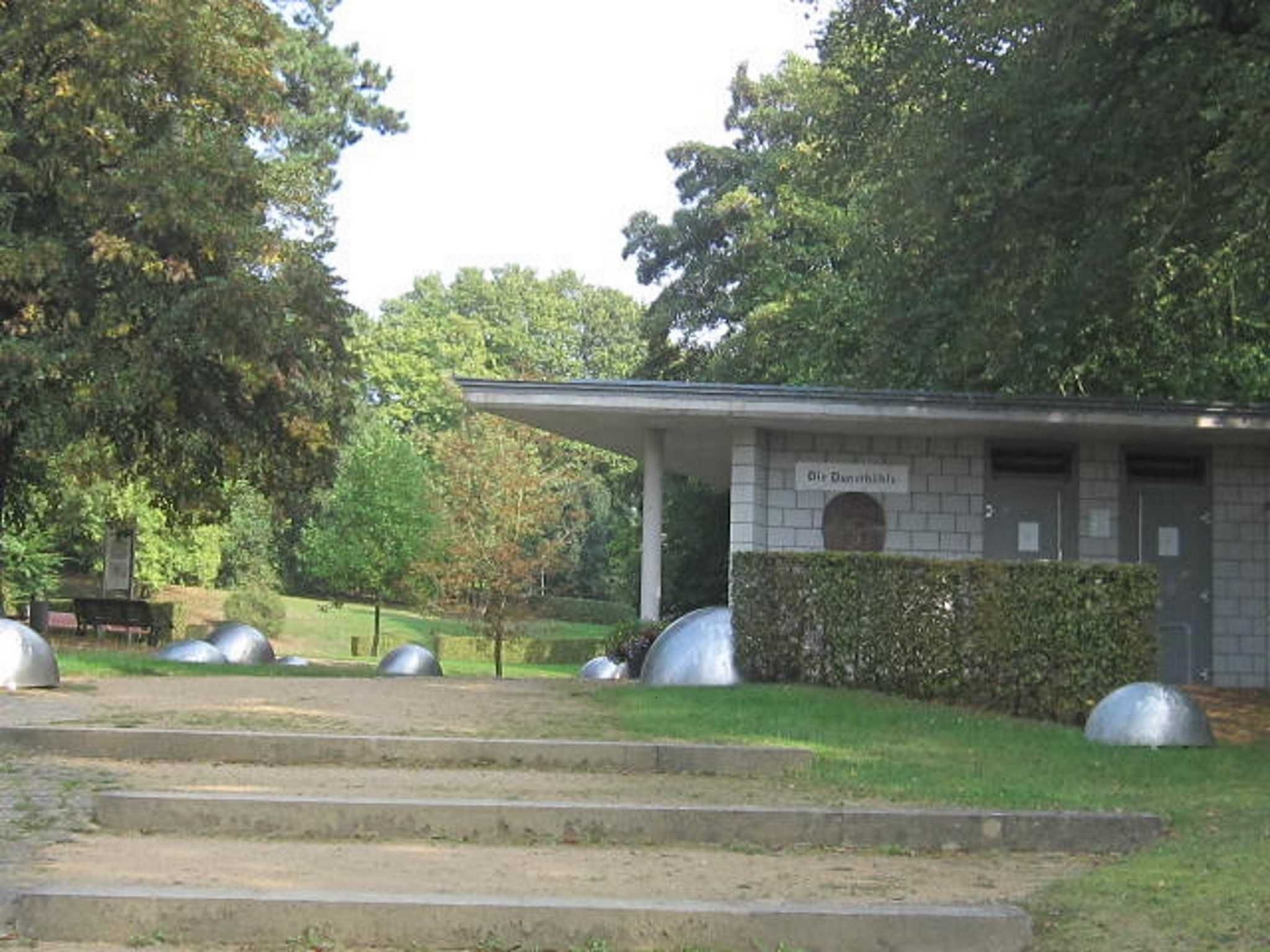 A building with a sign that reads 'Olle Danmarks,' surrounded by a grassy area with steps leading up to it.