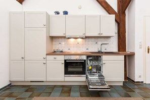 Kjøleskap, ovn, oppvaskmaskin og høy barnestol