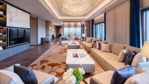 A spacious living room with a large chandelier, a flat-screen TV, and a comfortable seating area with sofas and a coffee table. - Gran Melia Chengdu (Chengdu)