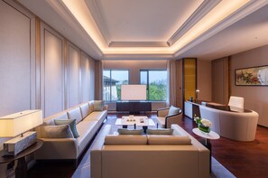 A spacious hotel lobby with a modern design, featuring a seating area with sofas and a coffee table, a reception desk, and large windows offering a view of the cityscape. - Gran Melia Chengdu (Chengdu)