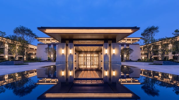 A modern building with a reflective pool in front, large windows, and a symmetrical design. - Gran Melia Chengdu (Chengdu)