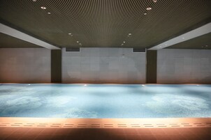Una piscina techada, sillones reclinables de piscina