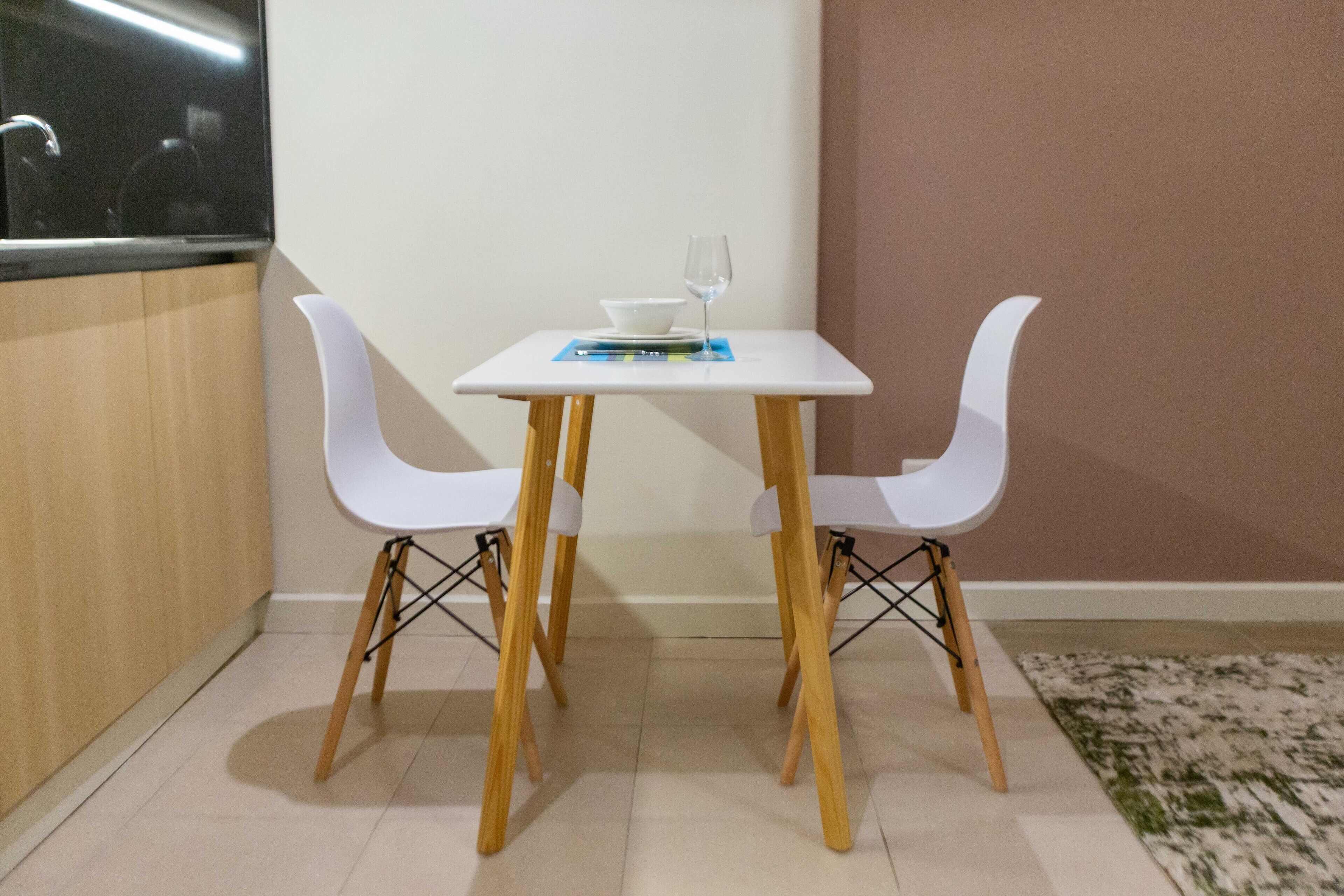 A small dining area with a white table and four white chairs.