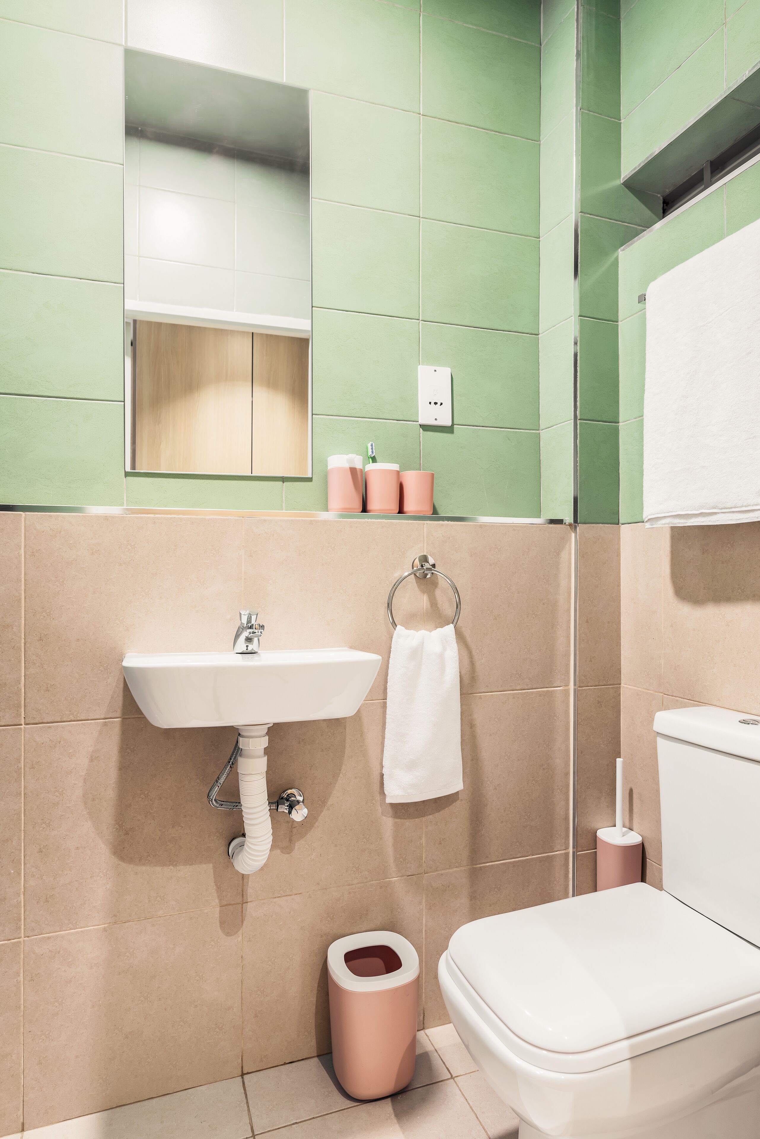 A bathroom with a sink, toilet, and mirror.