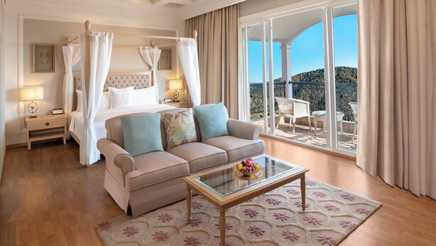 A bedroom with a four-poster bed, a sofa, a glass coffee table, and a balcony with outdoor furniture. - Welcomhotel by ITC Hotels, Tavleen, Chail (Shimla)