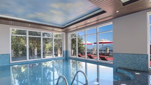 An indoor swimming pool with clear glass walls, a wooden ceiling, and a view of outdoor umbrellas and trees. - Welcomhotel by ITC Hotels, Tavleen, Chail (Shimla)