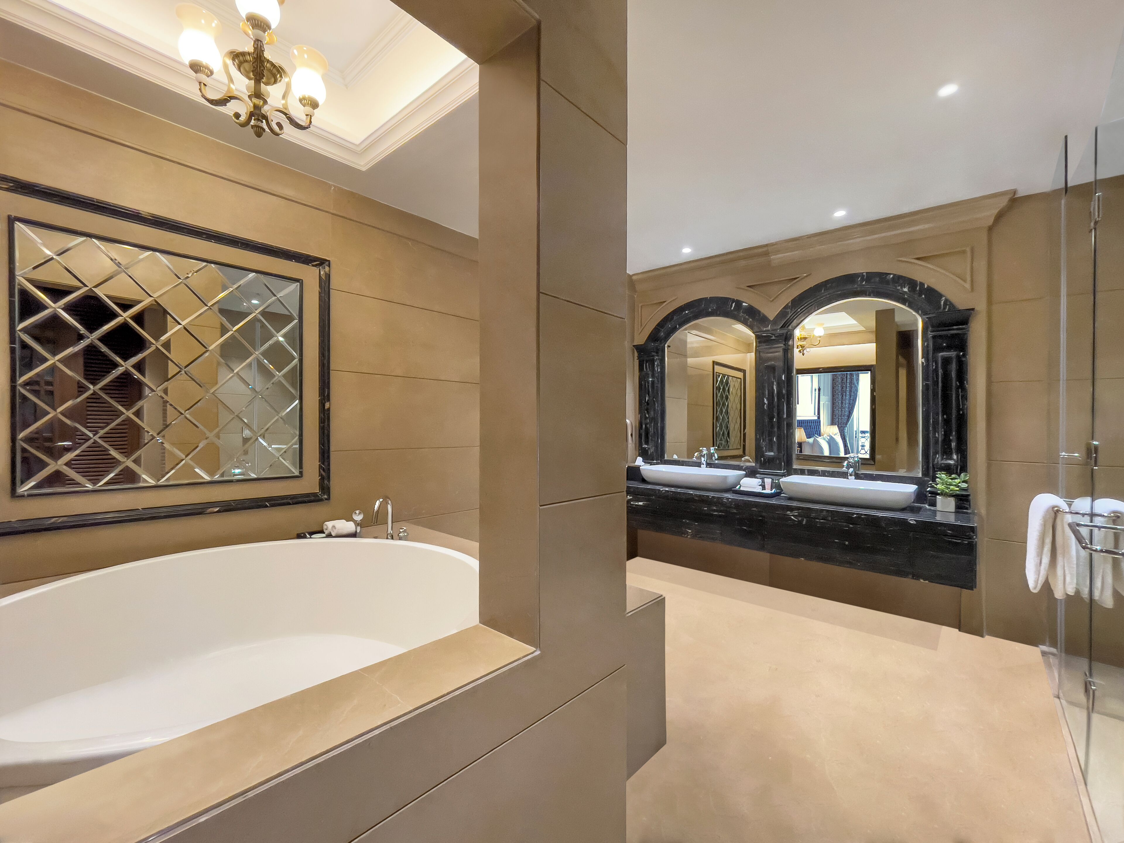 A modern bathroom with a large freestanding bathtub, a double sink vanity, and a large mirror.