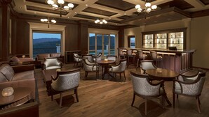 A spacious lounge area with leather seating, a bar with a wine display, and large windows offering a view of the mountains. - Welcomhotel by ITC Hotels, Tavleen, Chail (Shimla)