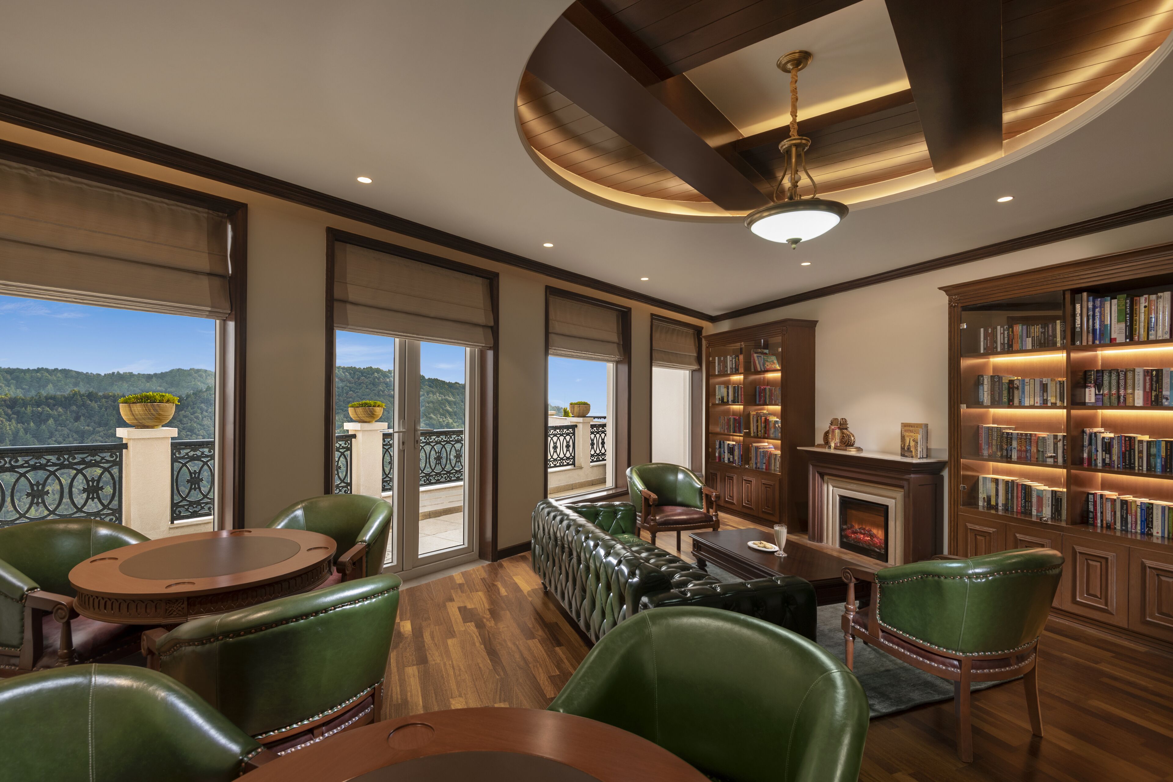 A spacious room with a fireplace, a large bookshelf, and a view of the outdoors.