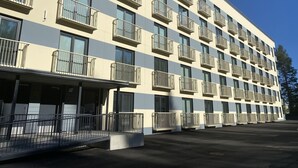 A multi-story hotel with balconies, a covered entrance, and a parking area. - Time Apartments Ylistönmäki (Jyväskylä)