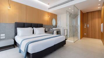 A modern bedroom with a large bed, bedside tables, a vanity with a mirror, and a walk-in closet.