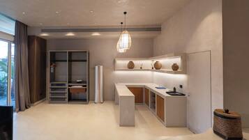 A modern kitchen with a built-in island, a hanging pendant light, and a view of the outdoors.