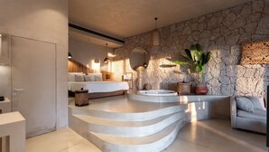 A modern bathroom with a stone wall, a freestanding bathtub, and a large mirror. - Empire Beach Resort ADULTS ONLY (Himarë)
