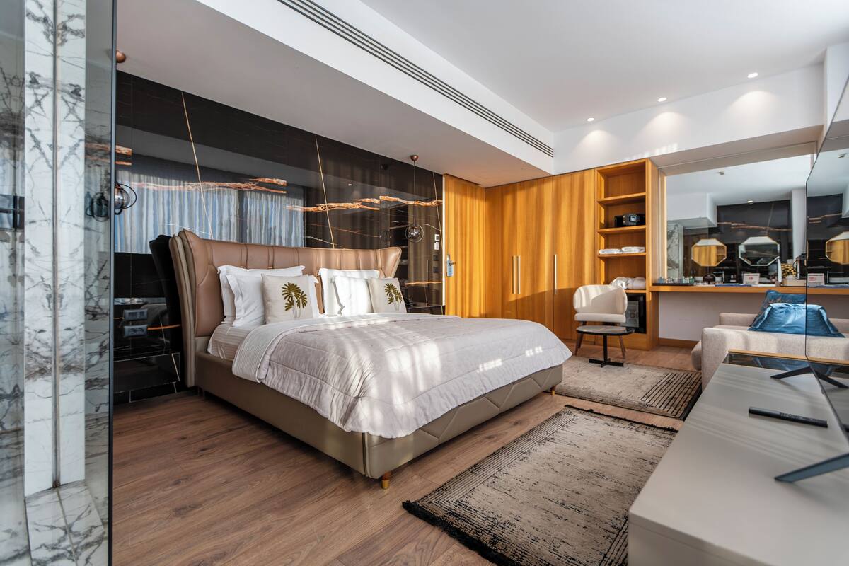 Un dormitorio moderno con una cama grande, un escritorio y un armario.