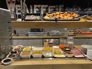 Un bufé con diferentes opciones de comida y una estación de café.